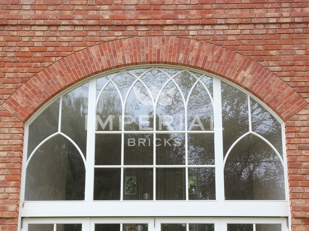 Close up of brick arch and dentil course using Reclamation Soft Red handmade bricks, above two storey window.