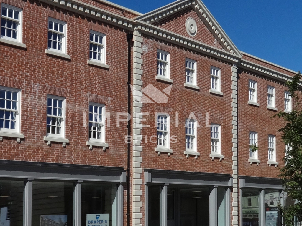 Side view of residential apartments above commercial listed buildings, restored using Soft Red handmade bricks.