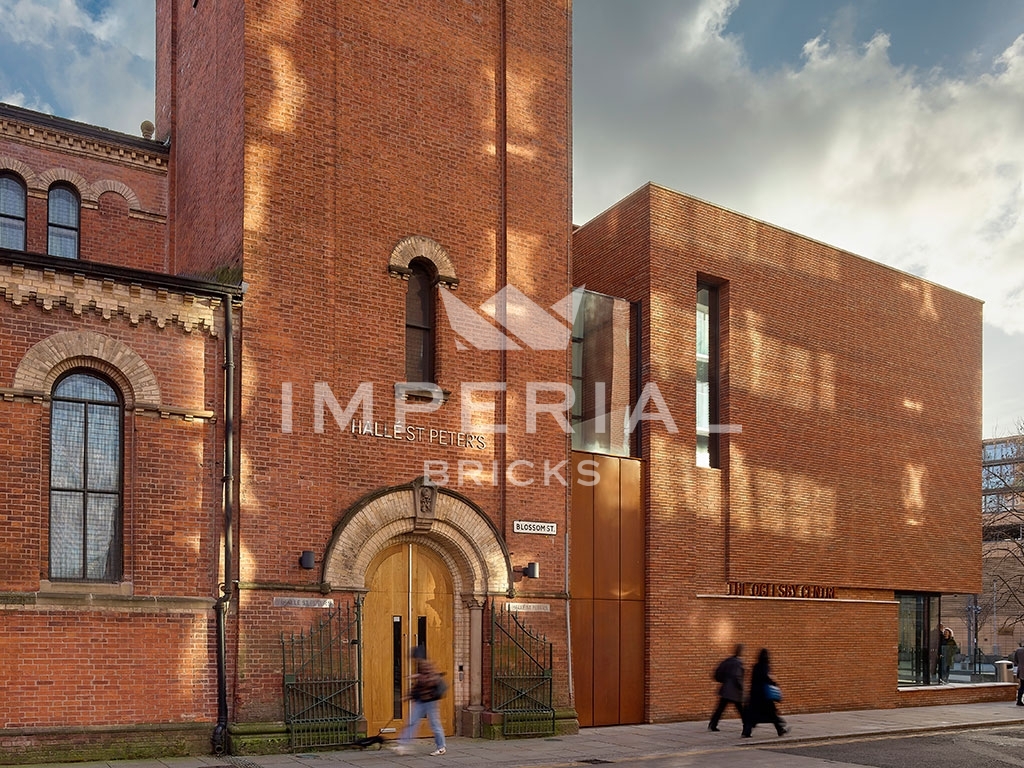 View from side of Halle St Peter's Church, showing extension built using a bespoke blend of red linear handmade bricks.