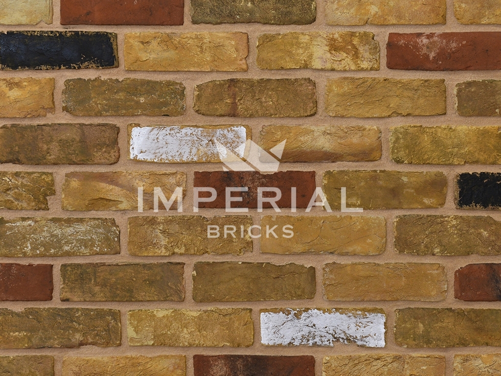 Reclamation Yellow Multi Stock bricks shown in a wall. The bricks are aged yellow stocks mixed with reds, and some black and white faces.