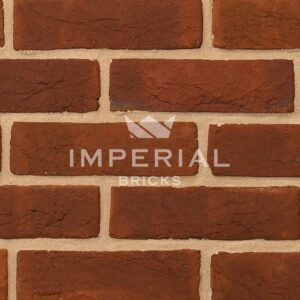 Georgian handmade bricks shown in a wall. The bricks are red, with orange and subtle plum tones. Zoomed in to show detail and texture.