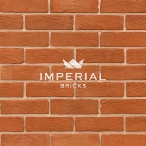 Heritage Soft Orange handmade bricks shown in a wall. The bricks have multi orange tones and creasing on the faces.
