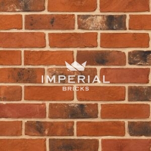 Imperial Blend handmade bricks shown in a wall. The bricks are mixed red and orange shades blended with darker weathered and subtly mortared bricks.