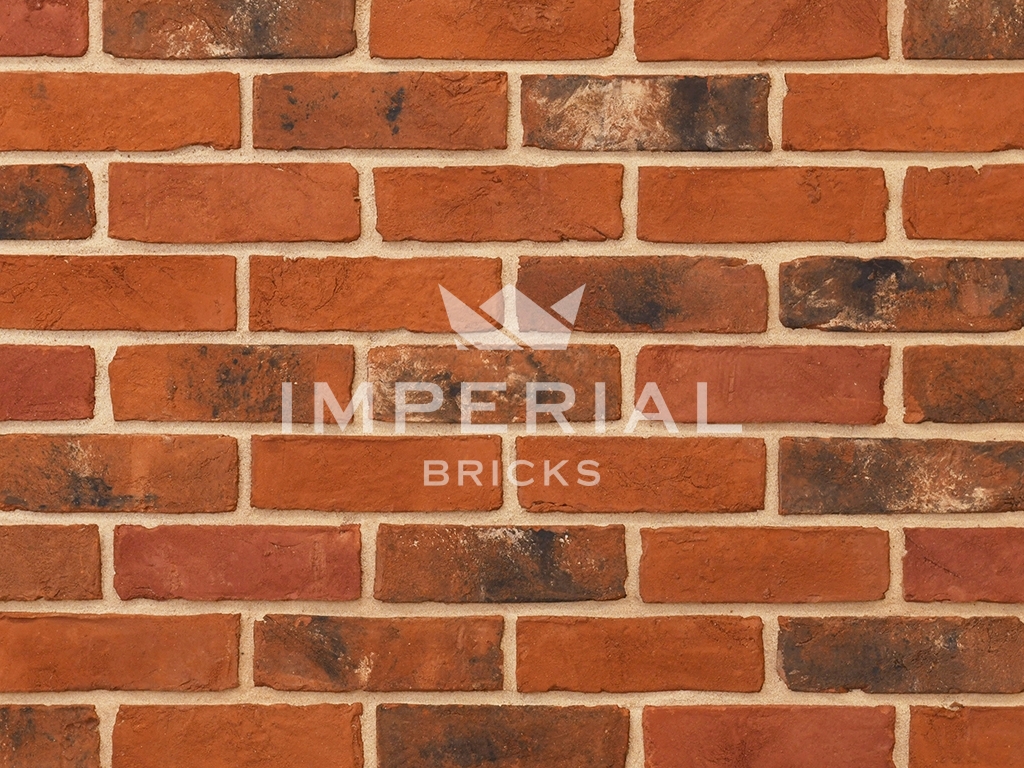 Imperial Blend handmade bricks shown in a wall. The bricks are mixed red and orange shades blended with darker weathered and subtly mortared bricks.