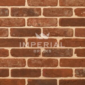 Reclamation Cheshire handmade bricks shown in a wall. The bricks are red with extensive weathering and mortar on the faces, and soft rustic edges.