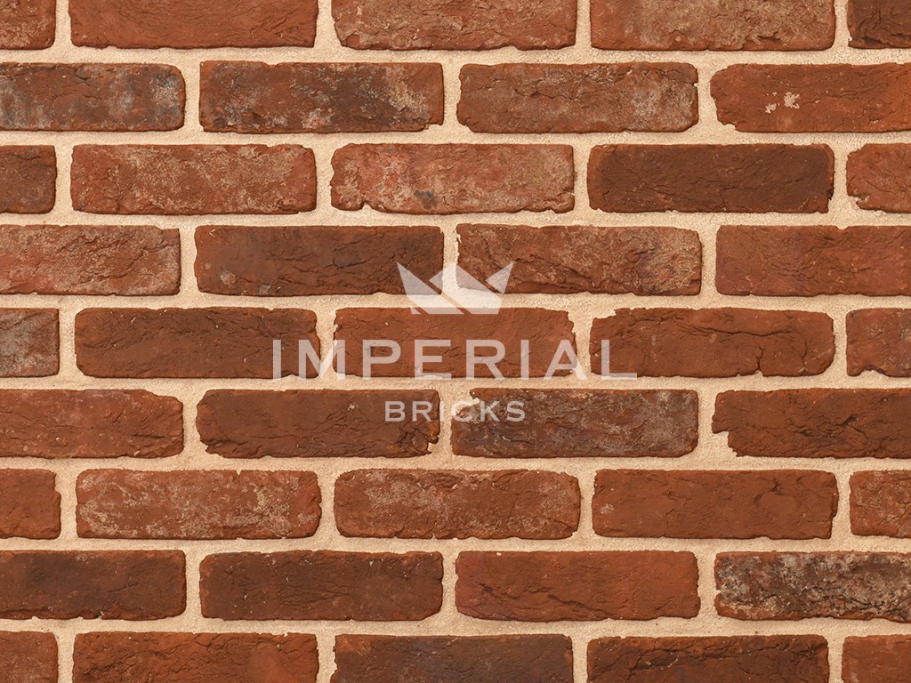 Reclamation Cheshire handmade bricks shown in a wall. The bricks are red with extensive weathering and mortar on the faces, and soft rustic edges.