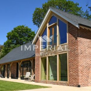 Large residential new build home built using Reclamation Cheshire handmade bricks. The bricks are complemented with a 2 storey oak frame and slate roof.
