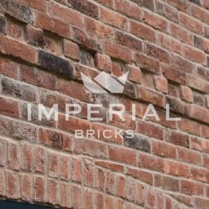 Corner of a residential self-build home, built using Reclamation Red Handmade bricks. Image is take close up to show the detail and texture in the brickwork