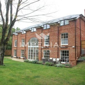 Large three storey self-build home, built using Reclamation Soft Red handmade bricks. The home has large Georgian style windows.