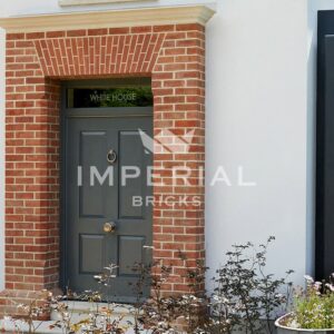 Door framed with Soft Red brick arch. The arch features a pre-fabricated arch above the doorway and several brick specials running vertically down each side.