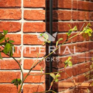 A wall built using Tudor Multi handmade bricks in a stack bond, which shows the texture and detail in the bricks.