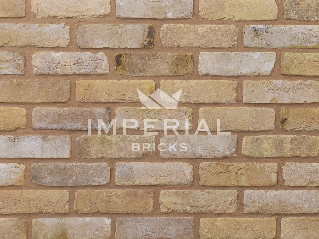 Tumbled Reclamation Buff handmade bricks shown in a wall. The bricks are a buff colour with soft edges and an aged, weathered finish.