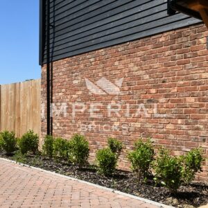 Close up of the side of a new build home, built using Tumbled Reclamation Red handmade bricks.