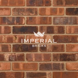 Tumbled Weathered Outside Blend bricks shown in a wall. The bricks have an orange/red base colour, pale banding, dark overburns, manufactured to replicate reclaimed bricks.