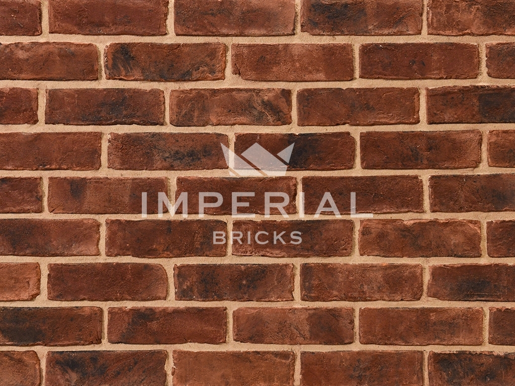 Urban Weathered bricks shown in a wall. The bricks have a red base colour with a sooted and dark weathered finish.