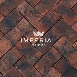 Balmoral Blend handmade pavers laid in the ground. The pavers are red with dark weathering and a sanded texture.