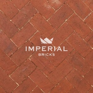 Russet extruded brick pavers laid in the ground. The pavers are a multi-tonal red colour with a dragfaced wire cut texture.