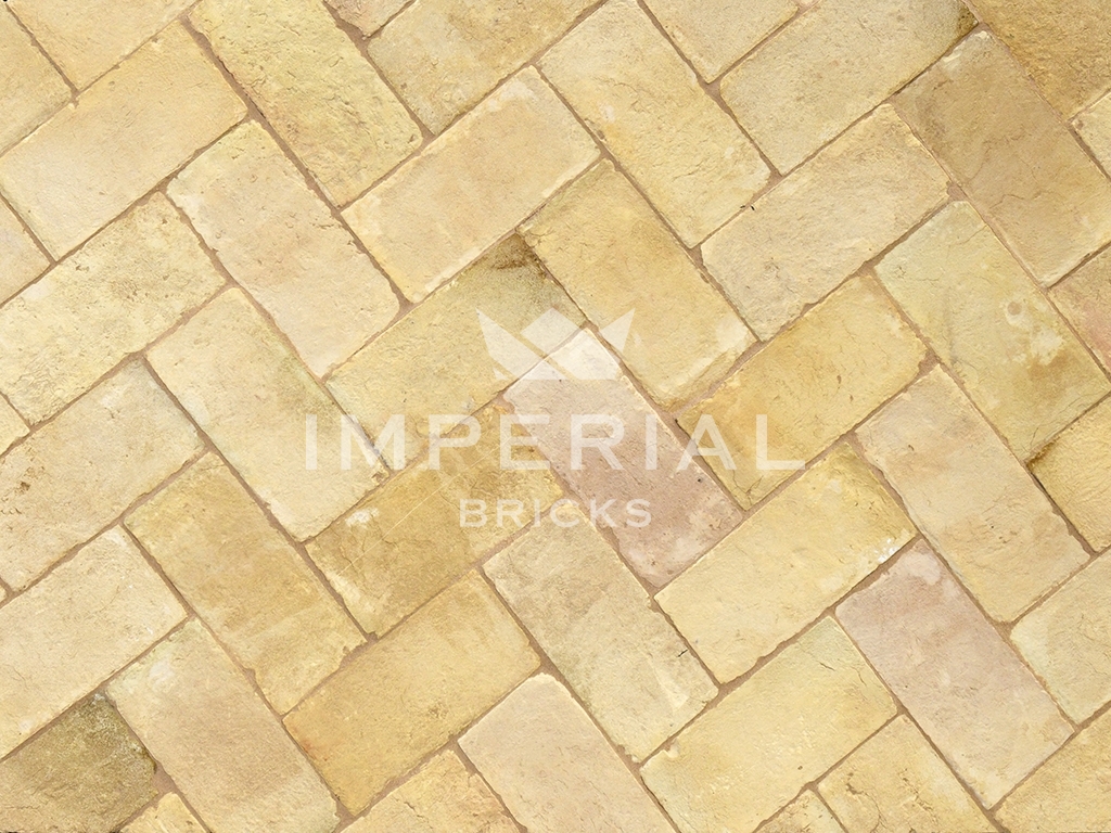 Suffolk Floor handmade paving bricks laid in the ground. The paving bricks are a buff yellow colour with some pale pink and grey tones.