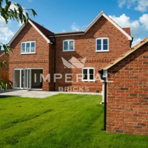 Rear view of detached self build property built using Country Blend handmade bricks. The side of a garage is shown to the right side, which also shows the texture of the bricks.