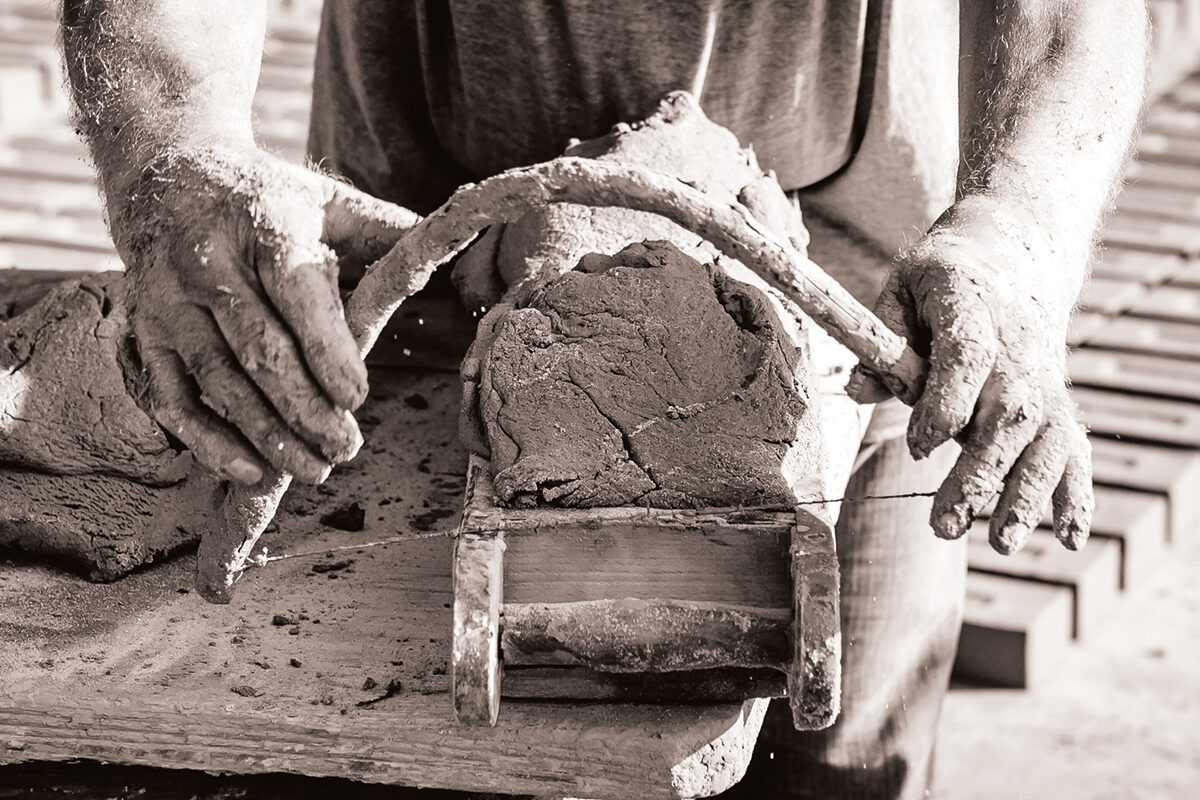 Man making clay brick in traditional wooden mould