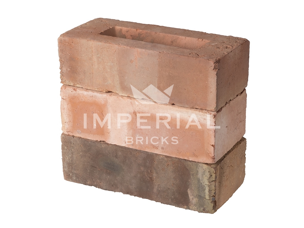 3 machine made bricks stacked on top of one another. The top brick has light weathering on the face and header, the middle brick is plain, and the bottom brick has darker weathering.