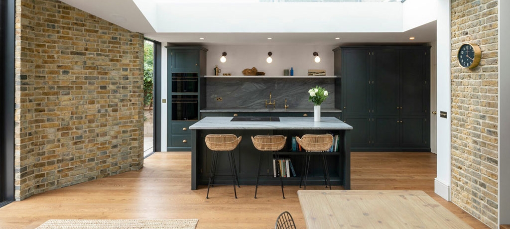 Interior of a kitchen extension. The walls to the right and left side of the image look like exposed brickwork, which were created using yellow handmade brick slips.