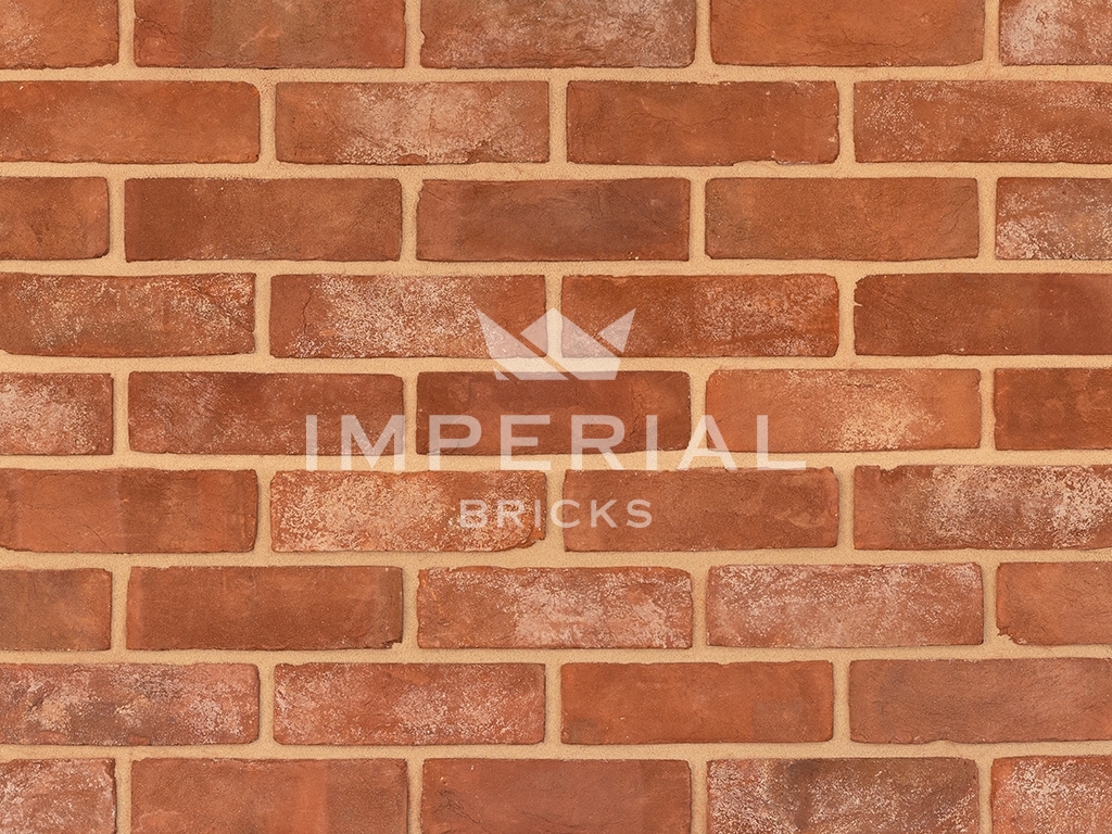 Reclamation Soft Red bricks shown in a wall. The bricks are red with a creased textured and a blend of mortared faces.