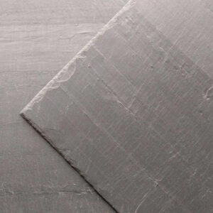 Rutland roof slate shown on a roof. The slate is a dark blue colour with a smooth texture.