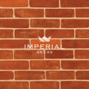 Regency Red Multi handmade bricks shown in a wall. The bricks are red blended with some oranges.