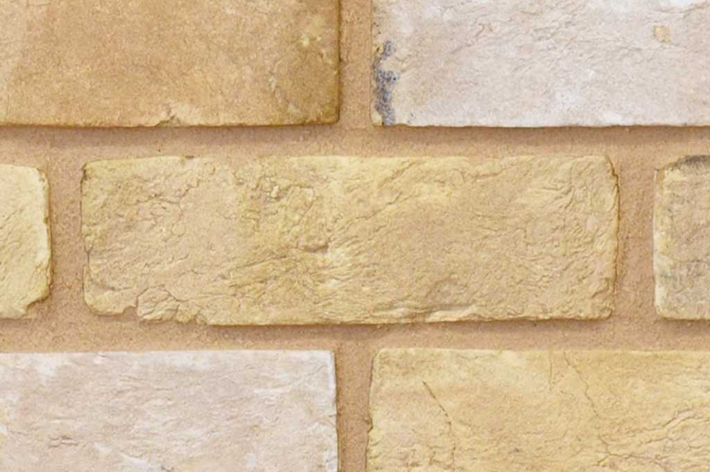 Handmade bricks in a wall, showing their creased texture and rough edges which are typical characteristics of handmade bricks.