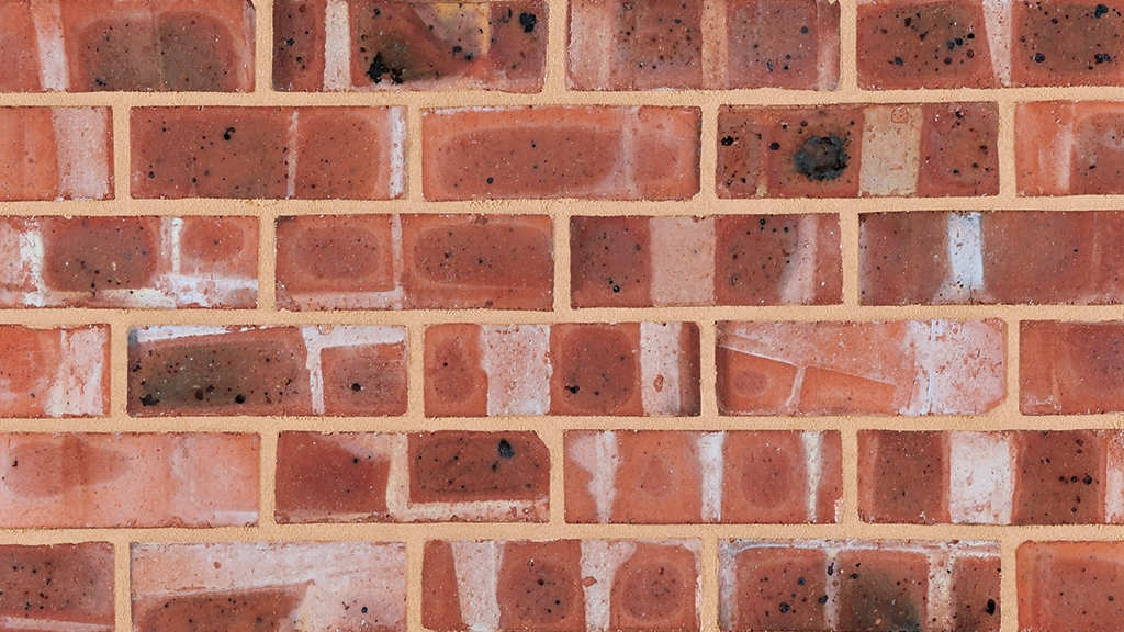 Example of colour banded bricks. The bricks are stacked in the kiln in a patter which restricts airflow between bricks, creating uneven heat and oxygen distribution across the faces. Some areas fire darker and others lighter, creating a striped/banding effect.