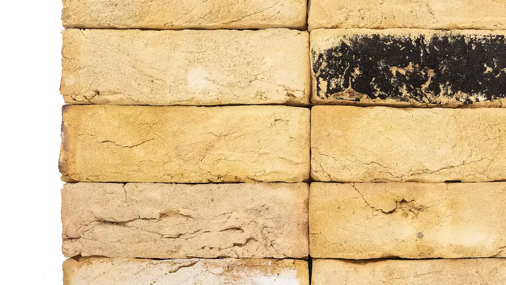 Close up image of London stock bricks. The bricks have yellow shade variations, prominent handmade creased texture and a sanded texture.
