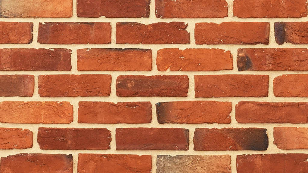 Multi-colour bricks example with varying red to orange colour shades. The bricks have dark red, brown and blue hues across the faces, intentionally created as a result of uneven heat distribution when firing in the kiln.