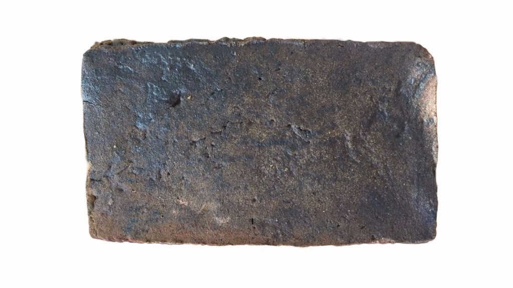 Vitrified blue header brick example, made by deliberately over-firing in a reduced-oxygen atmosphere. It produces a glassy blue-grey colour and significantly reduces permeability.