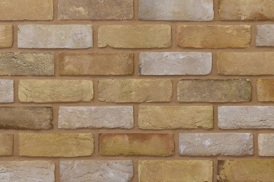 Example of buff handmade bricks with an aged finish shown in a wall. The bricks have both weathered and pale wash finishes.