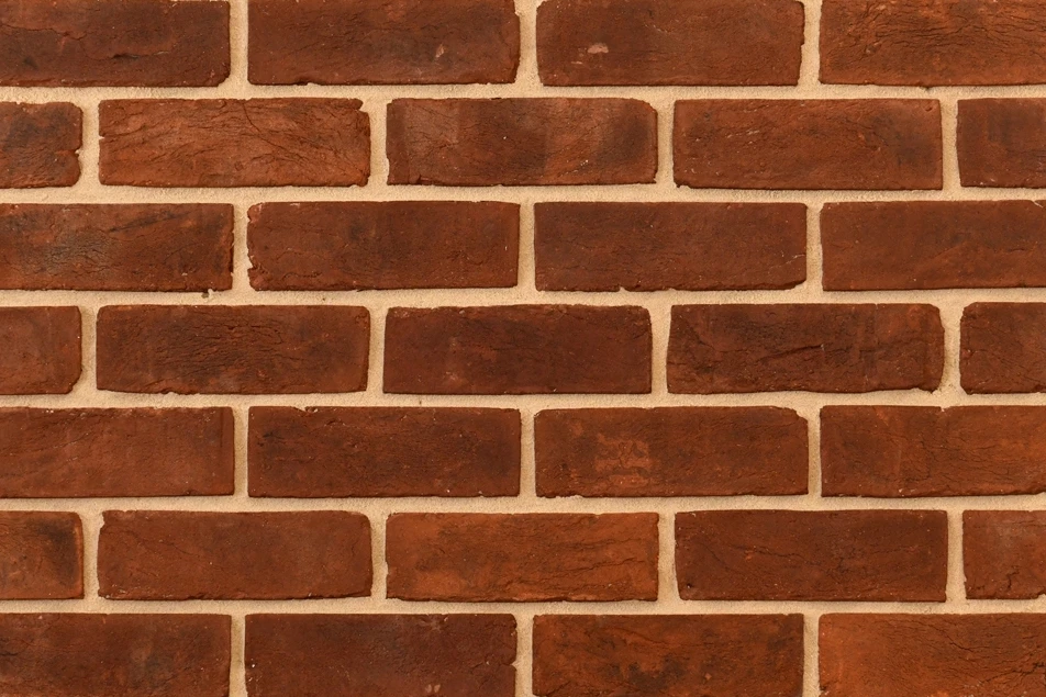Example of red handmade bricks with a weathered finish shown in a wall. The bricks have varying levels of weathering, from light to medium.