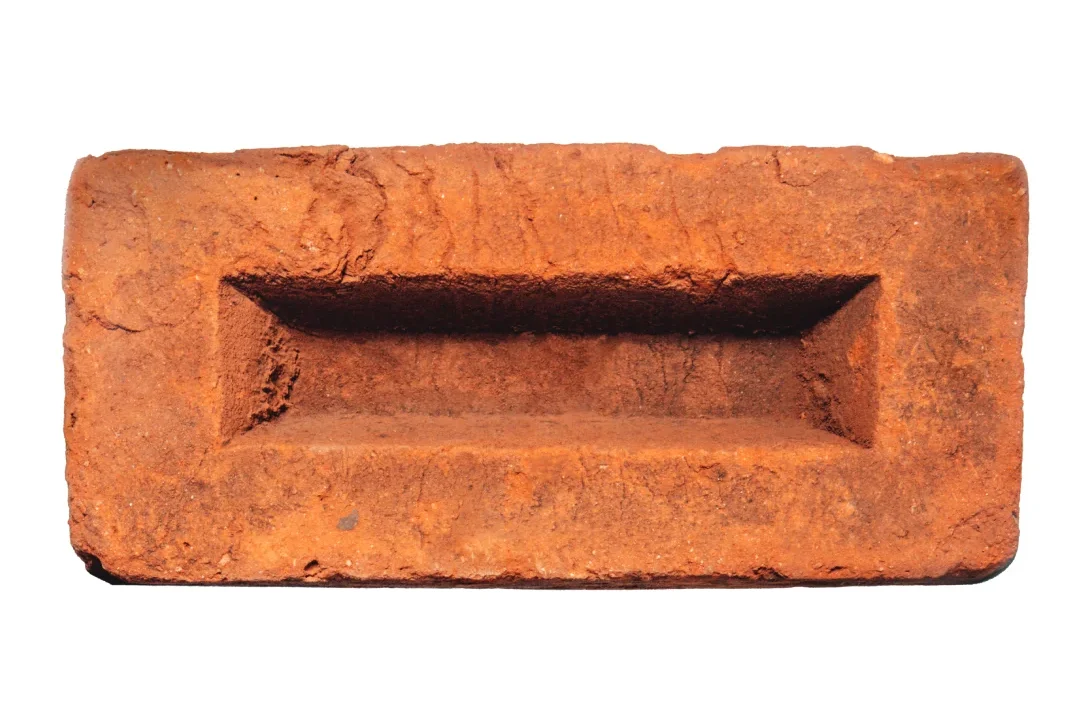 Single handmade brick with a rectangular brick frog (also known as a frogged brick) on a white background.