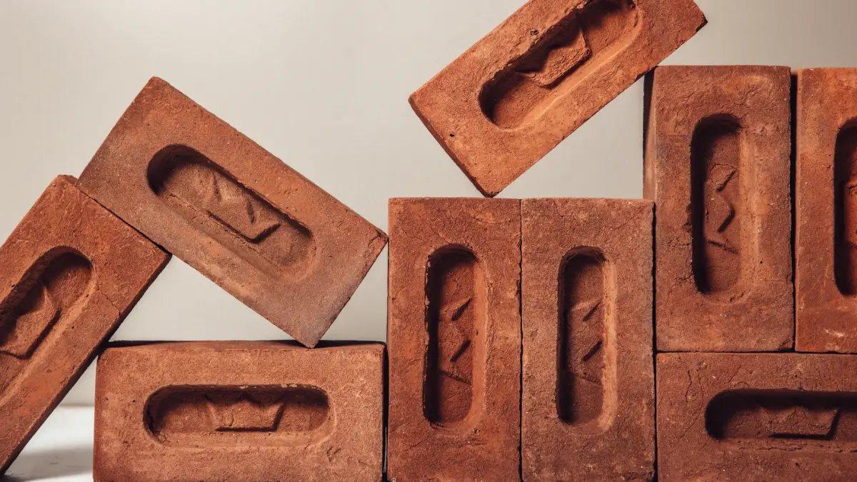 Red handmade frogged bricks stacked in a display. The brick frogs are an oval shape with Imperial branding.