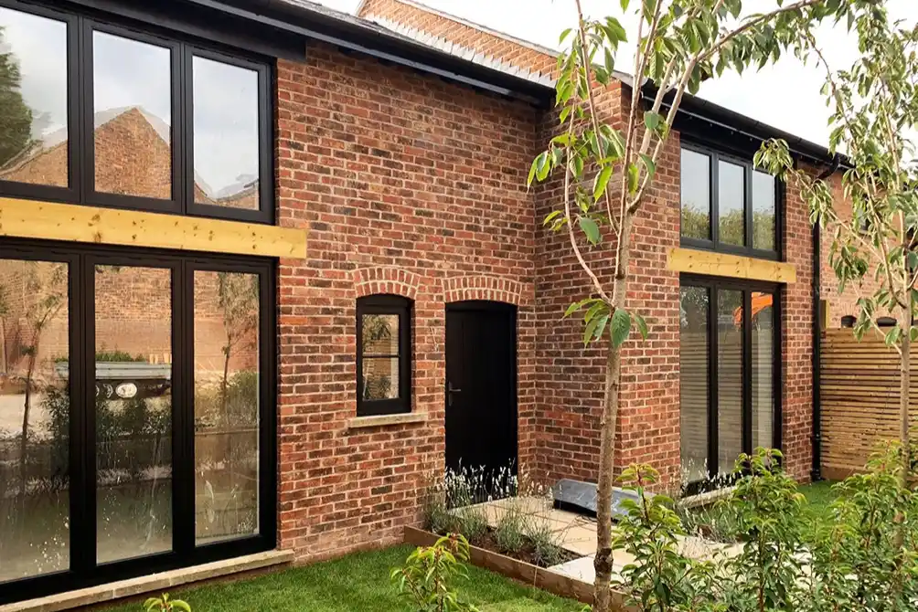Project example of a barn-style new build home built using standard off-the-shelf weathered bricks.