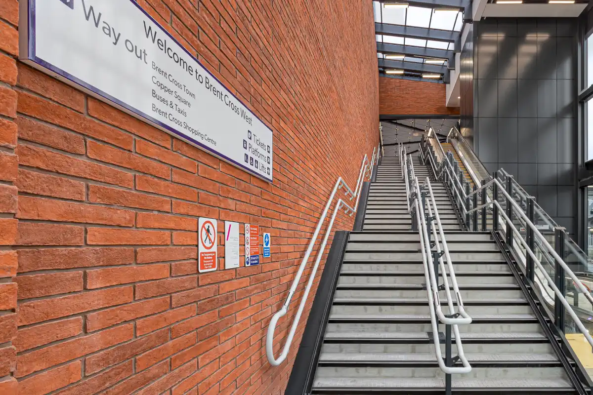 Internal view of a staircase inside Brent Cross West Station against a wall of Farmhouse Orange handmade linear bricks.