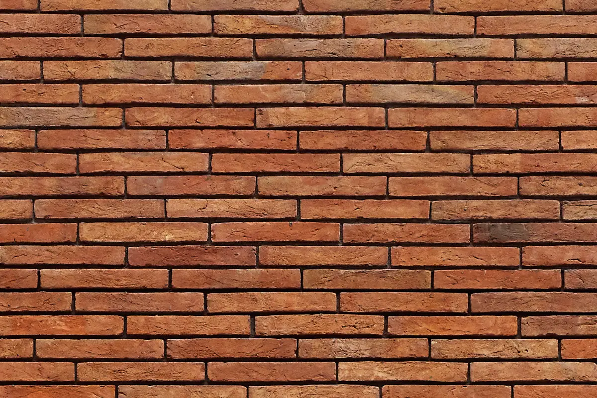A wall of red multi handmade linear bricks laid in an offset stretcher bond. Each brick is offset by approximately two thirds of the width of one beneath, creating a stepped appearance.